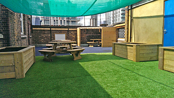 School roof area transformed with seating, planters and faux grass